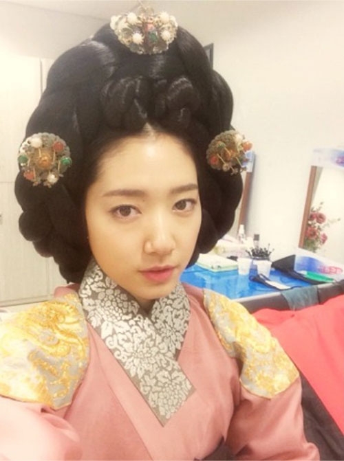 배우 박신혜의 기자시사회에서 찍은 셀카를 공개했다. 사진 속 박신혜는 영화 ‘상의원’의 첫 촬영날의 모습이었다. 가채를 쓰고 한복을 입고 중전마마로의 변신을 마친 상태. 연한 분홍색에 어깨에는 용 자수가 들어간 은은하면서도 고급진 한복을 입은 박신혜는 영화 속에서 맡은 역이 중전마마인 만큼 카메라를 향해 무표정을 지음으로써 단아함을 지켰다.  사진출처=박신혜 인스타그램