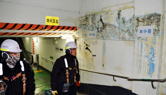 11일 제2롯데월드 공사장 관계자가 물이 흐른 자국이 선명하게 보이는 서울 잠실역 공영주차장 출입구 부분 벽을 지나가며 살펴보고 있다.  박윤슬 기자 seul@seoul.co.kr