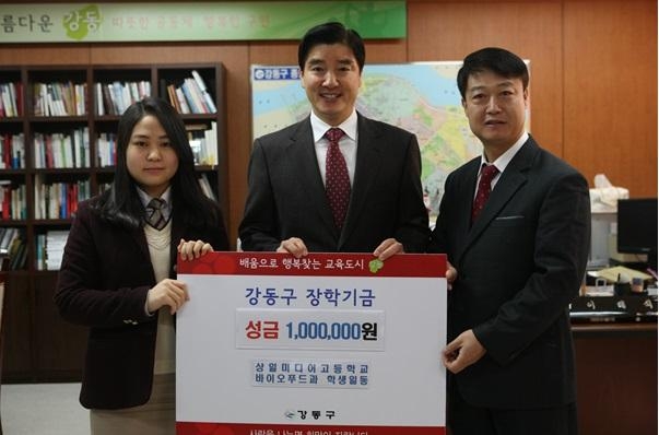 지난 16일 강동구청에서 박소연(왼쪽) 상일미디어고등학교 바이오푸드과 1학년 학생이 친구들과 카페 운영으로 모은 100만원을 이해식(가운데) 구청장에게 장학기금으로 전달하고 있다.  강동구 제공