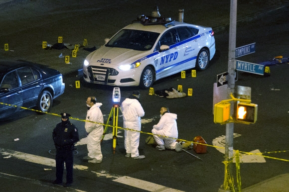 순찰차에 타고 있던 경관 2명이 흑인 폭력배의 무차별 총격에 의해 숨진 20일(현지시간) 미국 뉴욕 브루클린 사건 현장에서 수사관들이 감식 등 조사를 벌이고 있다. 뉴욕 AP 연합뉴스
