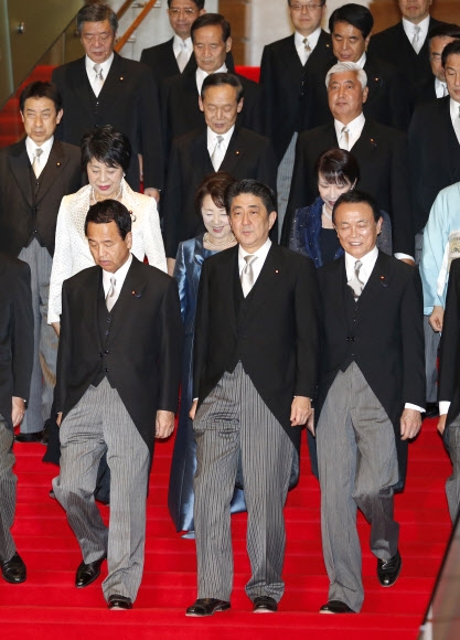24일 일본 도쿄 수상관저에서 이날 새로 출범한 ‘제3차 아베 내각’ 관계자들이 기념 촬영 뒤 걸어 나오고 있다. 앞줄 가운데 아베 신조 총리가 내각 관계자들을 이끌고 있다. 도쿄 AP 연합뉴스