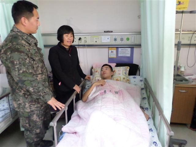 지난 23일 아버지에게 자신의 신장을 떼어 준 이순성(오른쪽) 상병이 31일 어머니(가운데)의 간호 속에 회복 치료를 받고 있다. 이 상병의 형 종금씨도 2010년 어머니에게 신장을 이식해줬다. 육군 제39보병사단 제공