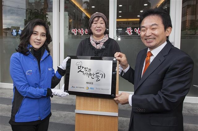 8일 제주 제주시 이도2동 ‘봄솔식당’이 호텔신라의 사회공헌 활동인 ‘맛있는 제주 만들기’ 8호점으로 선정돼 재개장되면서 이부진(왼쪽) 호텔신라 사장과 원희룡(오른쪽) 제주지사가 정옥선(가운데) 사장이 지켜보는 가운데 현판을 부착하고 있다.  호텔신라 제공