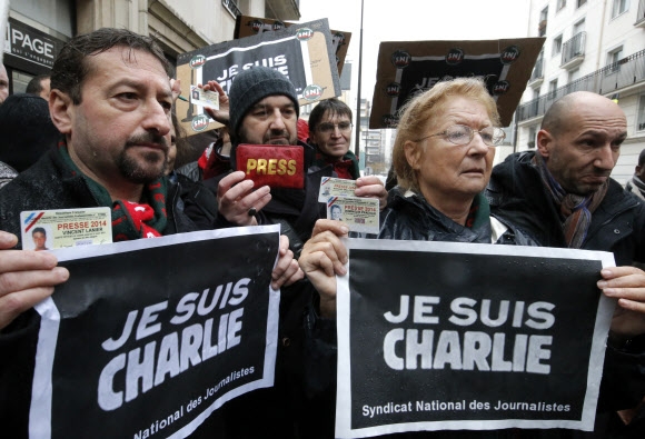 프랑스 언론인들이 8일 테러 사건으로 직원 10명이 희생된 주간지 샤를리 에브도 사무실 앞에서 기자증과 ‘내가 샤를리다’(Je Suis Charlie)라는 문구가 적힌 손팻말을 들고 침묵 시위를 벌이고 있다.  파리 AP 연합뉴스