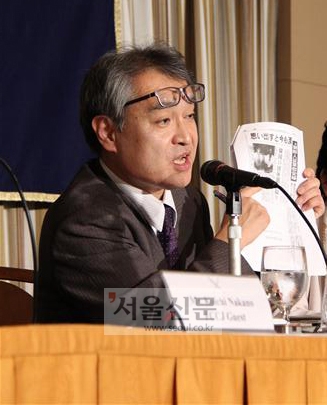 일본군 위안부 피해자의 증언을 처음으로 보도한 우에무라 다카시(56) 전 아사히 신문 기자가 9일 일본 도쿄에서 열린 주일 외국 특파원단 기자회견에서 당시 신문의 사본을 들어 보이고 있다.
