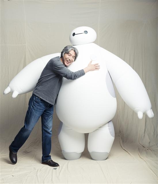 김상진 월트디즈니 수석 캐릭터 디자이너가 지난 14일 서울 여의도 한 호텔에서 가진 인터뷰에 앞서 자신이 슈퍼바이저로서 총괄 작업을 진행하며 만들어낸 ‘빅 히어로’의 치료 로봇 베이맥스를 껴안으며 활짝 웃고 있다.   월트디즈니코리아 제공