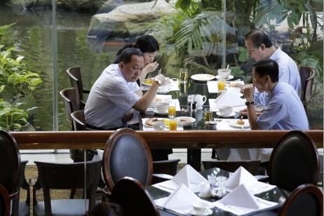 북한과 미국의 비공식 대화가 18일 싱가포르에서 시작됐다. 리용호(왼쪽 앞) 북한 외무성 부상이 수행원들과 아침 식사하는 모습.  AP 연합뉴스 