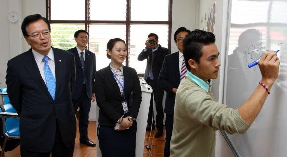 정의화(왼쪽) 국회의장이 24일 라오스의 수파노봉 대학을 방문, 한글로 ‘사랑합니다’라고 칠판에 쓰는 학생을 웃으며 바라보고 있다. 국회 제공