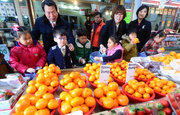 12일 서울 중랑구 망우동 우림시장에서 어린이들이 나진구(뒷줄 왼쪽 첫 번째) 중랑구청장과 함께 전통시장 장보기 체험을 하고 있다. 정연호 기자 tpgod@seoul.co.kr