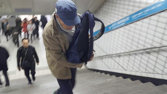 심씨가 지하철 4호선 사당역에서 택배 물건이 든 가방을 들고 출구 계단을 오르고 있다.