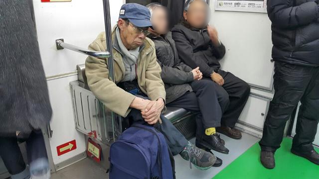 심맹수(왼쪽)씨가 지난 13일 지하철 교통약자 배려석에 앉아 택배 물건이 든 가방을 꼭 쥔 채 잠시 눈을 붙이고 있다.