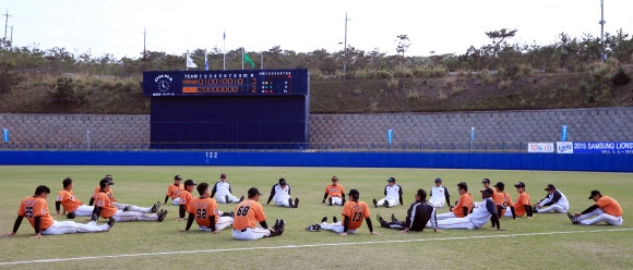 프로야구 한화 선수들이 22일 일본 오키나와현 아카마구장에서 열린 삼성과의 연습경기를 끝낸 뒤 원을 그리고 앉아 몸을 풀고 있다. 이날 경기는 한화가 3-2로 이겼다. 오키나와 연합뉴스