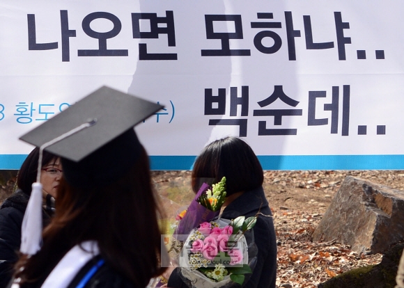23일 서울 연세대학교에서 열린 졸업식에서 한 학생이 취업에 대해 자조적인 글이 적힌 현수막 앞을 지나고 있다.  박지환 기자 popocar@seoul.co.kr
