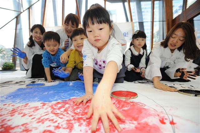 26일 송파구청 1층 로비에서 열린 특별한 태극기 만들기 행사에 참가한 어린이들이 빨강, 파랑 물감을 손바닥에 찍어 태극기를 꾸미고 있다. 송파구 제공