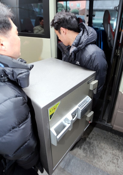 공군 전자전 훈련장비 도입 사업 비리 의혹이 제기된 무기중개업체 일광공영에 대한 압수수색이 실시된 11일 검찰 수사관들이 서울 성북구 돈암동 일광공영 본사에서 압수한 금고를 통째로 들고 나오고 있다. 연합뉴스