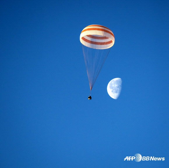 미국항공우주국(NASA) 소속 우주비행사 배리 윌모어, 러시아 연방 우주국(로스코스모스) 소속 알렉산더 사모쿠티야에프와 엘레나 세로바를 태운 러시아의 소유즈 TMA-14M 우주선이 12일(현지시간) 카자흐스탄의 제즈카즈간 지역 인근에 착륙하는 모습이 보인다.  ⓒAFPBBNews=News1