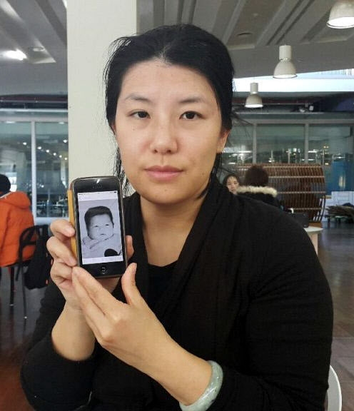 5년째 생모를 찾는 김은영씨가 16일 자신의 어린 시절 사진이 담긴 휴대전화를 들어 보이고 있다. 연합뉴스