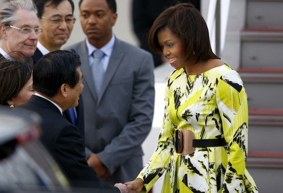 일본을 처음 방문한 미국 퍼스트레이디 미셸 오바마(오른쪽)가 도쿄 하네다 국제공항에서 영접 나온 일본 관료와 악수하고 있다.  도쿄 AP 연합뉴스