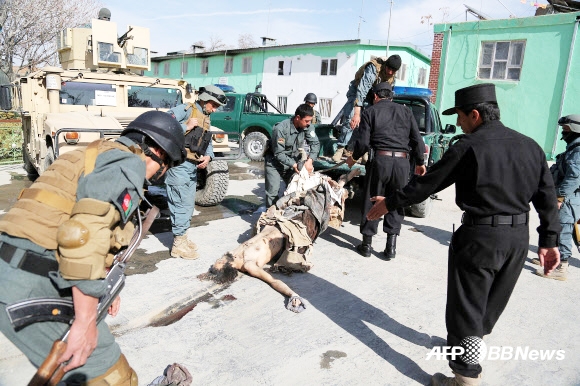 19일(현지시간)  아프가니스탄 간지 주 안다르 지역의 한 마을에서 이슬람 원리주의 무장세력 탈레반과 아프간 치안군 간의 한바탕 전투가 끝난 후 아프간 국가경찰(ANP)들이 마프간 대원으로 추정되는 시신을 수습하고 있다. ⓒAFPBBNews=News1