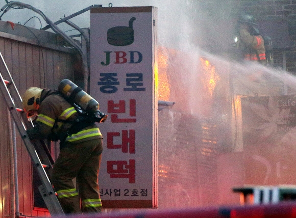 23일 오후 서울 종로구 세종문화회관 인근 식당가에서 화재가 발생해 소방대원들이 진화작업을 하고 있다. 연합뉴스