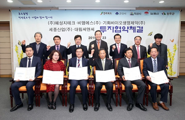 23일 전북도청에서 열린 투자 협약식에서 기업 대표들과 송하진(뒷줄 가운데) 전북도지사 등 지방자치단체장들이 화이팅을 외치고 있다. 전북도 제공