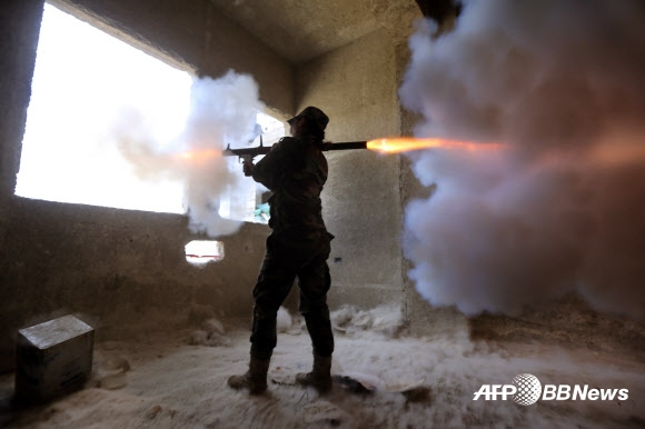 25일(현지시간) 시리아 수도 다마스쿠스에서 ‘공화국 수비대대’ 소속 시리아 여성 군인이 로켓추진식 수류탄을 발사하고 있다. ⓒAFPBBNews=News1