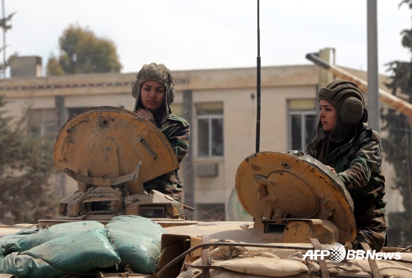 25일(현지시간) 시리아 수도 다마스쿠스에서 ‘공화국 수비대대’ 소속 시리아 여성 군인이 탱크를 조종하고 있다.  ⓒAFPBBNews=News1