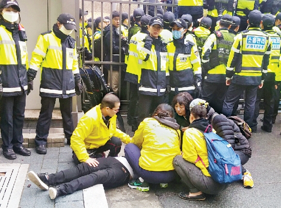 세월호 유가족들이 6일 정부세종청사 해양수산부 항의 방문에 나섰다가 정문에서 경찰의 제지를 받자, 일부가 해수부 담을 넘었고 이 중 한 명이 쓰러져 있다.  세종 강주리 기자 jurik@seoul.co.kr