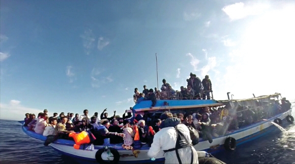 내전과 가난에 시달리는 아프리카와 중동 지역의 난민들이 리비아 해안 도시에 모여 낡은 어선을 개조한 선박에 몸을 의지한 채 유럽행을 시도하고 있다. 사진은 이탈리아 해상구조대원들이 지난 12일(현지시간) 시칠리아 해안에 도착한 아프리카 난민들을 구조하기 위해 다가가고 있는 모습.  시칠리아 AFP 연합뉴스
