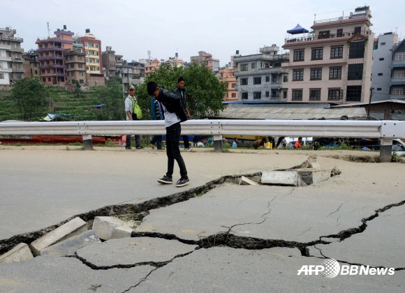 네팔 수도 카트만두에서 강진이 일어난 지 하루가 지난 26일 구조 대원이 무너져버린 도로를 살펴보고 있다. 25일 발생한 규모 7.8의 강진으로 네팔인 수천명이 사망했다. ⓒAFPBBNew=News1