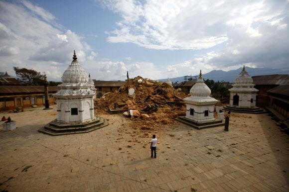 규모 7.8의 네팔 대지진으로 사흘째 구조작업이 계속되는 가운데 사망자가 3200명을. 부상자가 6500명을 넘어섰다. 다라하라 탑을 비롯해 카트만두 계곡의 유네스코 세계문화유산 7곳 중 4곳이 파괴되는 등 네팔의 저명한 문화재들이 이번 지진으로 많이 훼손된 가운데 26일 한 주민이 네팔에서 가장 오래된 사원 중 하나인 사원이 파괴된 현장에 서 있다.  ⓒAP/뉴시스