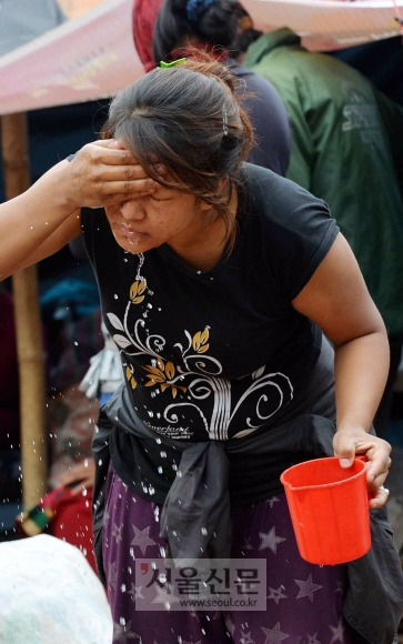 네팔 대지진 공식 사망자가 6100명을 넘어선 가운데 1일 임시 텐트에서 생활하고 있는 카트만두 주민이 컵에 담긴 물로 얼굴을 씻고 있다.  카트만두(네팔) 손형준 기자 boltagoo@seoul.co.kr