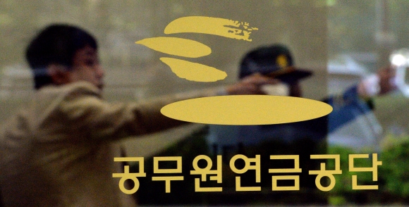 여야가 합의한 공무원연금 개혁안에 청와대와 정부, 공무원단체 등이 반발하고 있는 가운데 4일 서울 강남구 언주로 공무원연금공단 서울지부에서 경비원과 한 시민이 어딘가를 가리키고 있다. 박지환 기자 popocar@seoul.co.kr