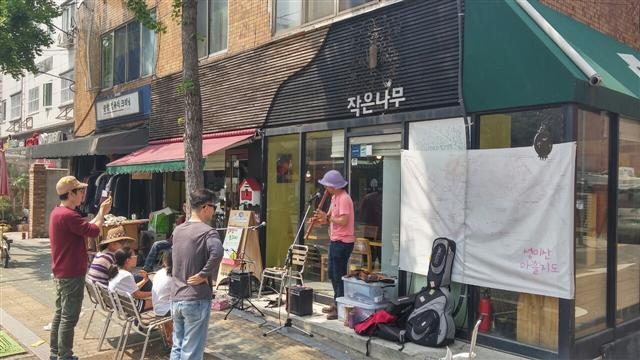 지난 1일 오후 서울 마포구 ‘작은나무’ 카페(마을기업) 앞에서 음악활동가인 황윤호성씨가 리코더 연주를 하고 있다.