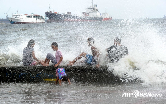 제6호 태풍 ‘노을’이 상륙한 필리핀 마닐라 항구에서 10일(현지시간) 필리핀 어린이들이 파도를 장난감 삼아 놀고 있다.  ⓒAFPBBNews=News1