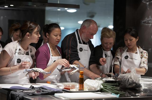 시드니수산물시장에서 운영하고 있는 요리교실에서 참석자들이 유명 레스토랑 요리사(가운데)의 게 손질 방법을 지켜보고 있다. 시드니수산물시장 제공