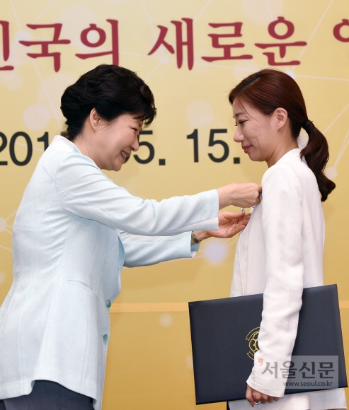 박근혜 대통령이 15일 청와대에서 열린 ’에볼라 대응 해외긴급구호대와의 대화’ 행사에서 김성혜 KOICA 보건전문관에게 국민포장을 수여하고 있다.  청와대사진기자단
