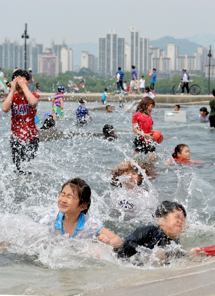 낮 최고기온이 30도 가까이 오르며 초여름 날씨를 보인 17일 서울 여의도 한강공원 물빛광장에서 어린이들이 물놀이를 하며 더위를 식히고 있다.손형준기자 boltagoo@seoul.co.kr