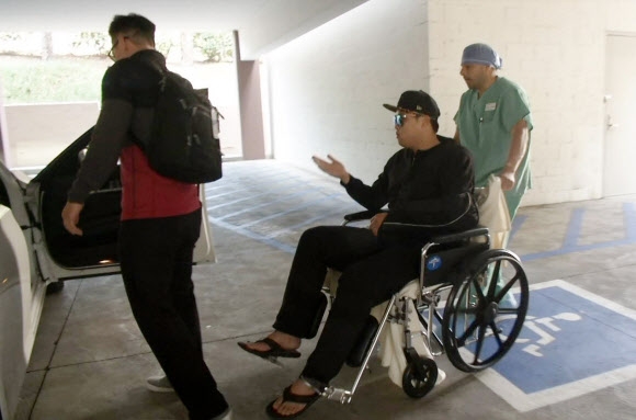 류현진이 22일 미국 로스앤젤레스 컬란-조브 정형외과에서 왼쪽 어깨 수술을 마친 뒤 휠체어를 탄 채 퇴원하고 있다.  로스앤젤레스 연합뉴스