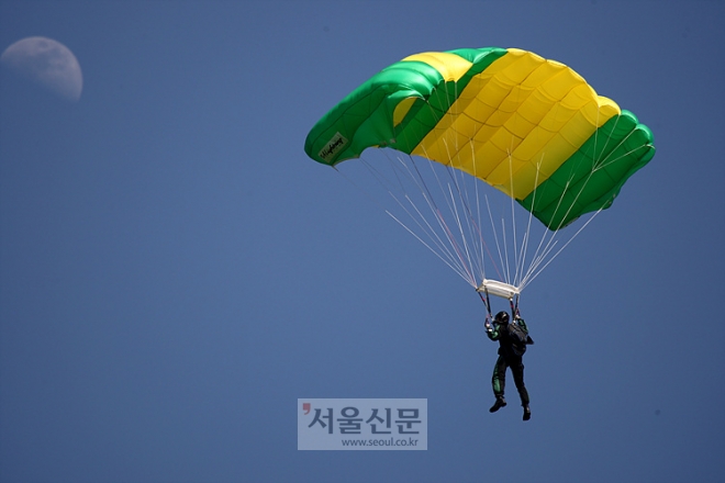 칼라색상의 낙하산을 펼친 교관이 엄청난 스피드로 낙하하고 있다. 교관급 요원들은 지상에서 기관총을 난사해도 맞추기 어려울 정도로 낙하속도가 빠르다.