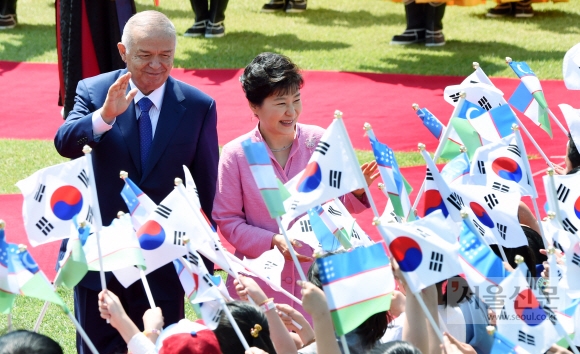 박근혜(오른쪽) 대통령과 당시 방한한 고(故) 이슬람 카리모프 우즈베키스탄 대통령이 28일 청와대에서 열린 공식 환영식에서 신길초등학교 학생들의 환영을 받으며 밝게 웃고 있다. 안주영 기자 jya@seoul.co.kr 
