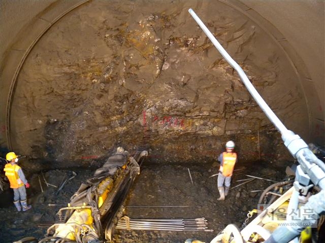 점보드릴이 암벽에 화약을 넣을 구멍을 뚫고 있다.