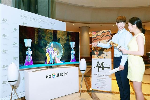 삼성전자 남녀 모델들이 5일 오페라 ‘주몽’이 공연될 서울 서초구 예술의전당 오페라극장에서 초고해상도(UHD) TV인 ‘SUHD TV’를 가리키고 있다.  삼성전자 제공 