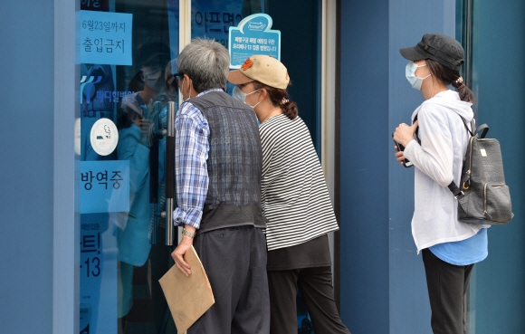 11일 서울시가 메르스 확산 방지를 위해 봉쇄한 양천구 신월동 메디힐병원에서 환자 가족들이 출입구 틈새로 병원 관계자와 얘기하고 있다. 손형준 기자 boltagoo@seoul.co.kr