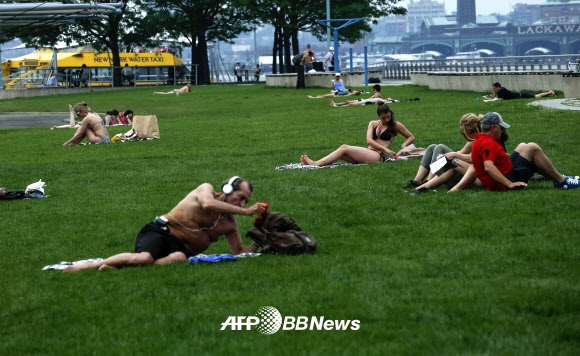 뉴욕 맨해튼 기온이 상승하자 사람들이 11일(현지시간) 허드슨 강가에서 일광욕을 즐기고 있다. ⓒ AFPBBNews=News1