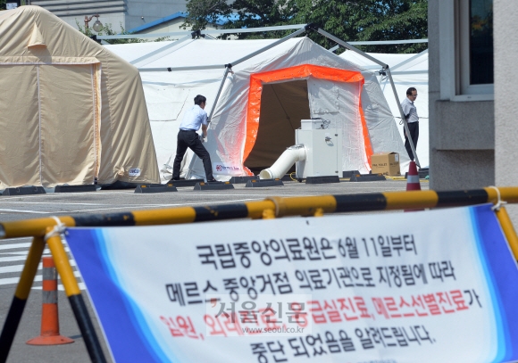 메르스 전담 치료 기관으로 지정된 국립중앙의료원의 관계자들이 12일 서울 중구 의료원 주차장에 음압격리 텐트를 설치하고 있다. 음압격리 병실이 부족할 경우를 대비한 조치다. 박지환 기자 popocar@seoul.co.kr