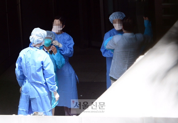 21일 서울 강남구 일원동 삼성서울병원 응급실 앞에서 의료진이 환자들에게 방역복을 입히고 있다. 이날도 이 병원 의사 1명이 메르스 확진 판정을 받아 병원 안팎의 긴장감이 가시지 않고 있다. 정연호 기자 tpgod@seoul.co.kr 