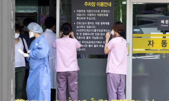 중동호흡기증후군(메르스) 사태가 장기화 국면에 접어든 가운데 22일 오후 강남구 삼성서울병원 의료진이 주차장에 설치된 메르스 대응 시설물에 들어서기 위해 마스크를 착용하고 있다.  연합뉴스