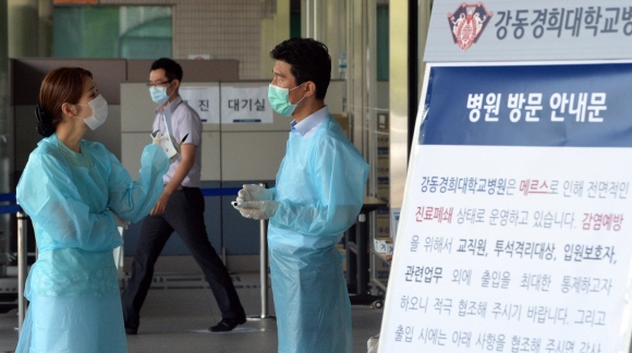 경희대 강동병원이 폐쇄된 22일 서울 강동구 강동경희대병원에서 의료진이 병원입구에서 이야기를 나누고 있다.  2015.6.22 박지환 popocar@seoul.co.kr