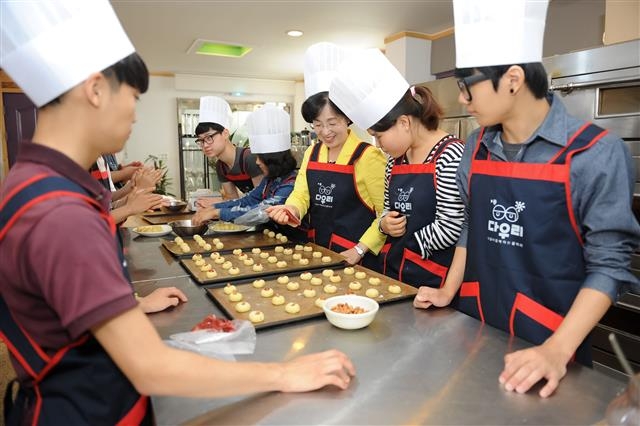 박춘희(오른쪽 세 번째) 송파구청장과 지역 청소년들이 지난 7일 서울 송파구 문정중앙침례교회의 다우리작은도서관에서 열린 송파 청소년 제과제빵 교실에서 과자 만들기를 하고 있다. 송파구 제공